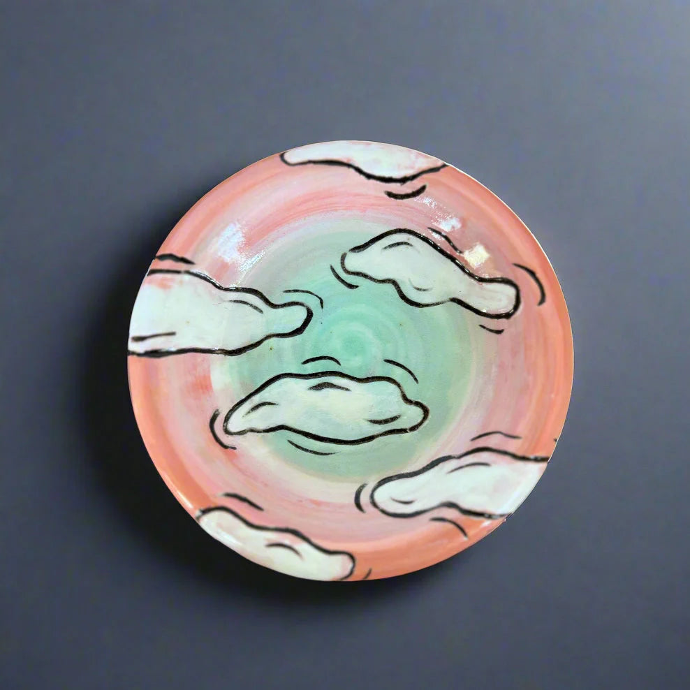 Round ceramic plate with cloud design on a dark background